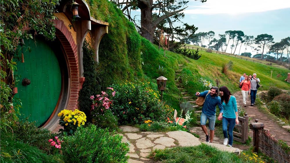 People are walking to the Hobbit's hole.