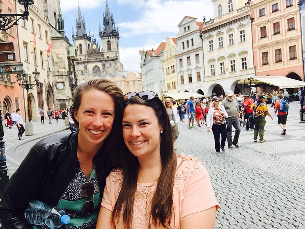 Two smiling women standing on the Old City Square.