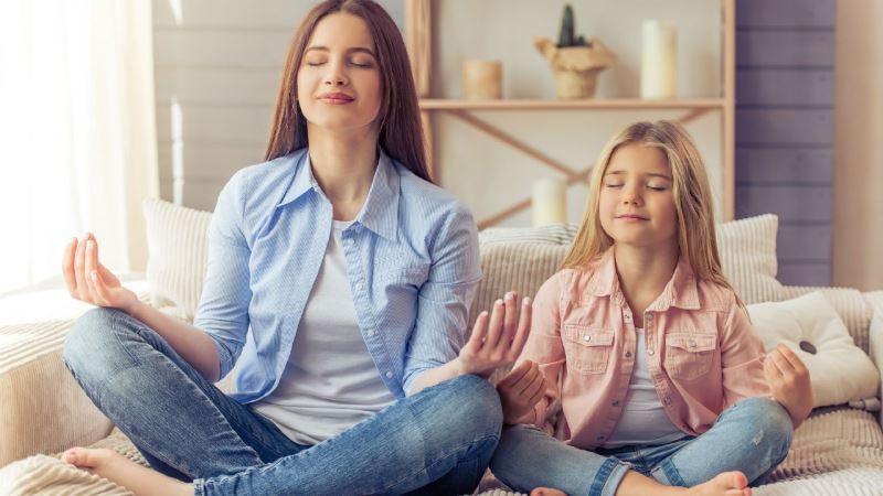 A mother meditating with her daughter