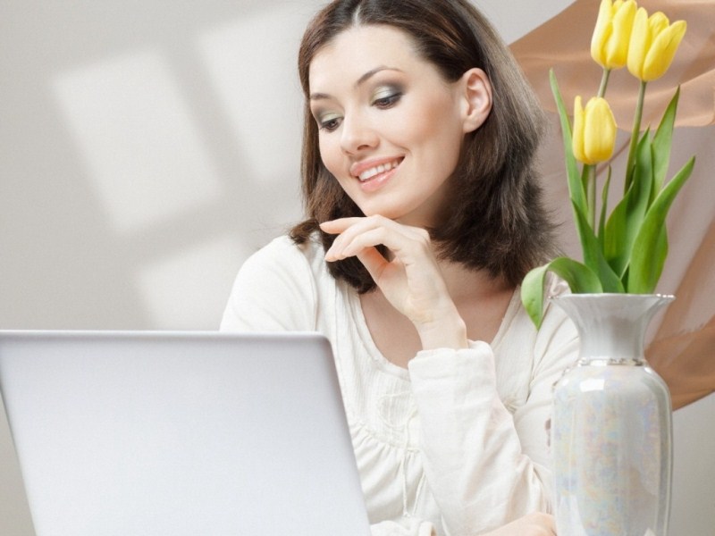 A girl behind the laptop smiling