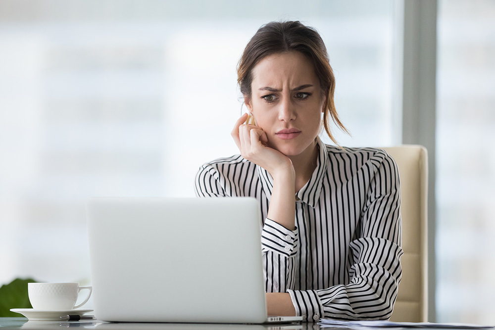 Confused businesswoman working on her laptop.