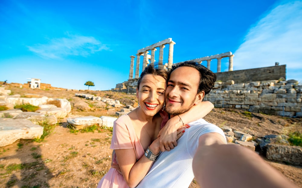 Couple taking selfie next to Cape Sounion.