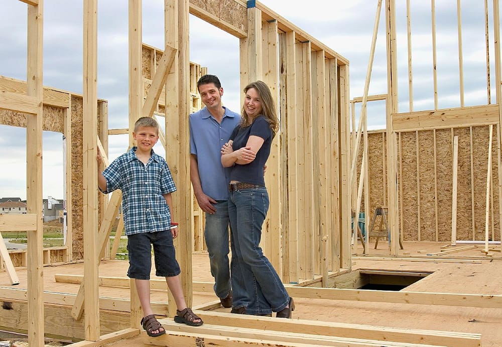 Family standing inside an unfinished house.