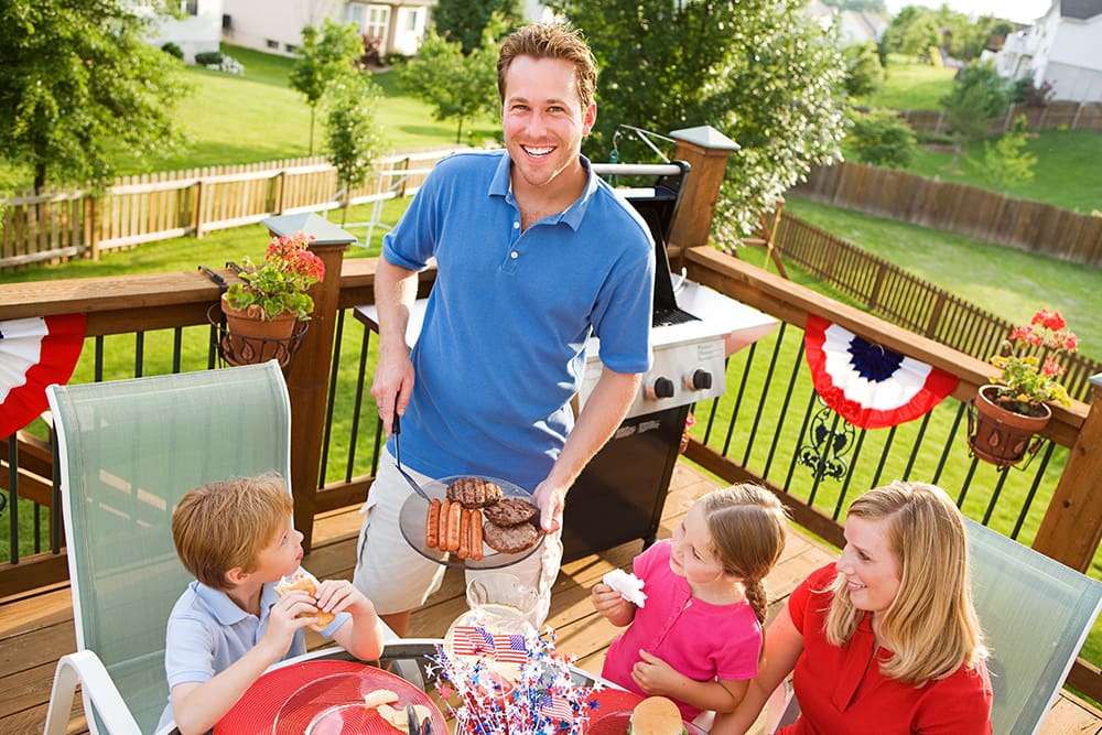 Family eating outside on a deck.