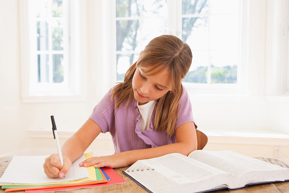 Girl writing in her notebook.