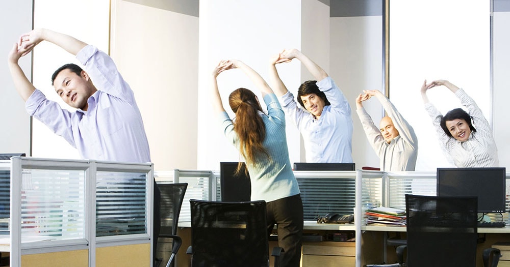 Office workers doing exercises at their working places.