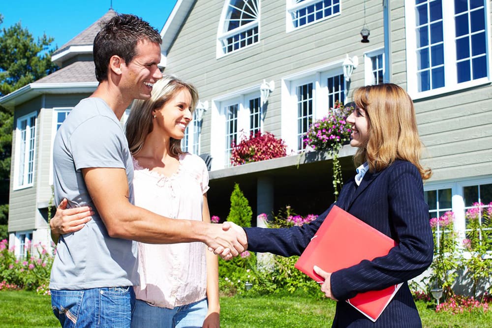 Woman shaking hands with a couple.