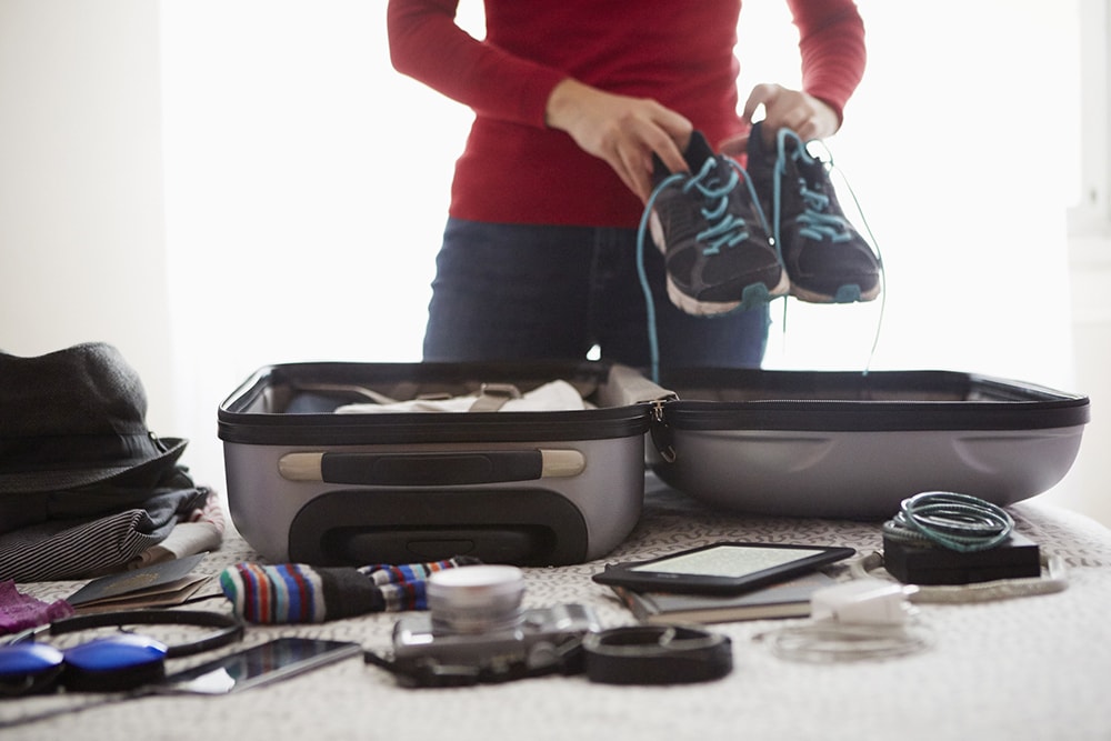 Person packing a suitcase.