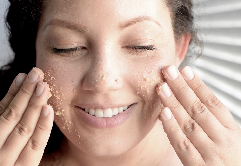 Woman applying face scrub.