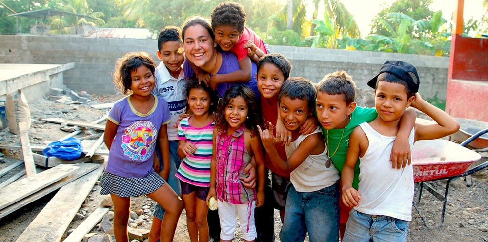 Smiling woman and children hugging.