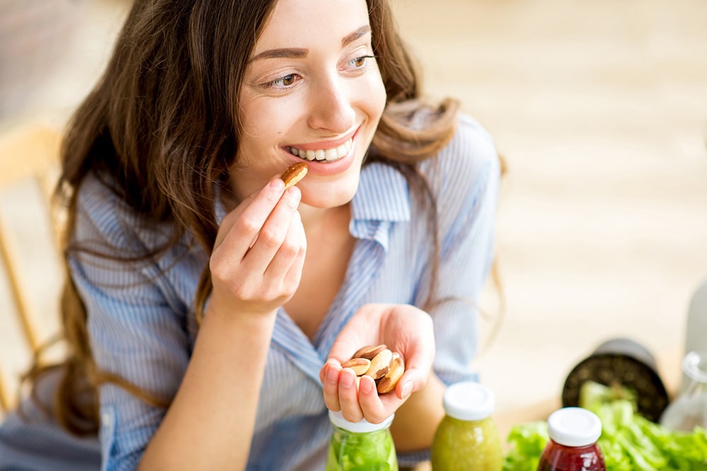 Woman eating nuts from her hand.