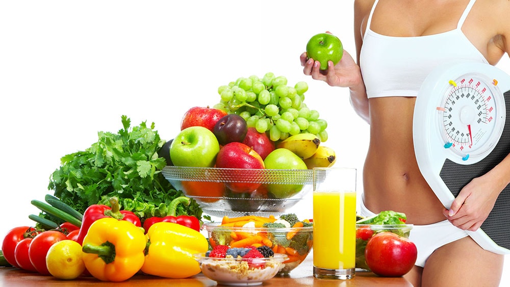 woman holding scales and an apple standing next to fruits 