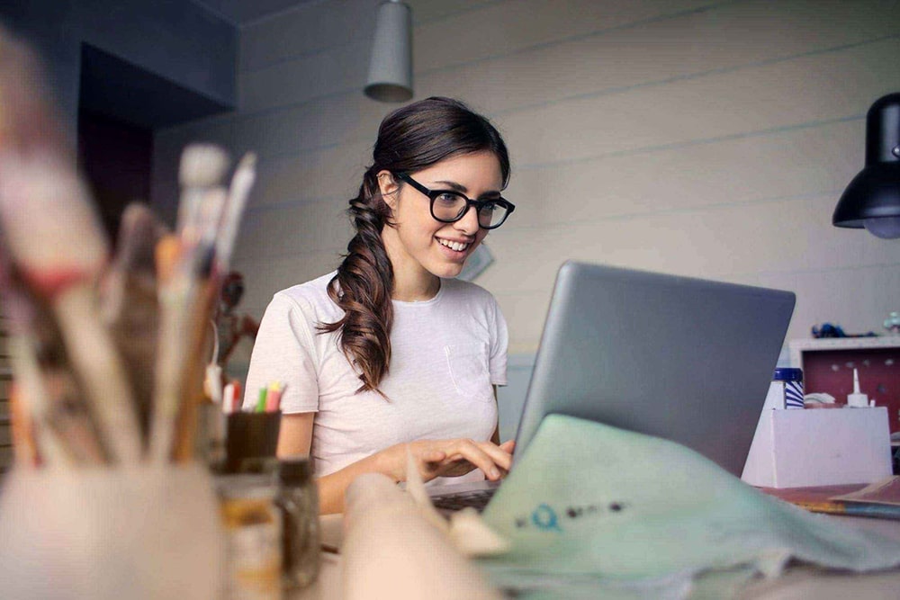 Woman sitting at the desk and typing on laptop.