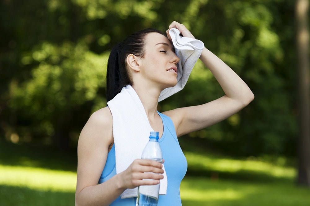 Woman wiping sweat with towel. 